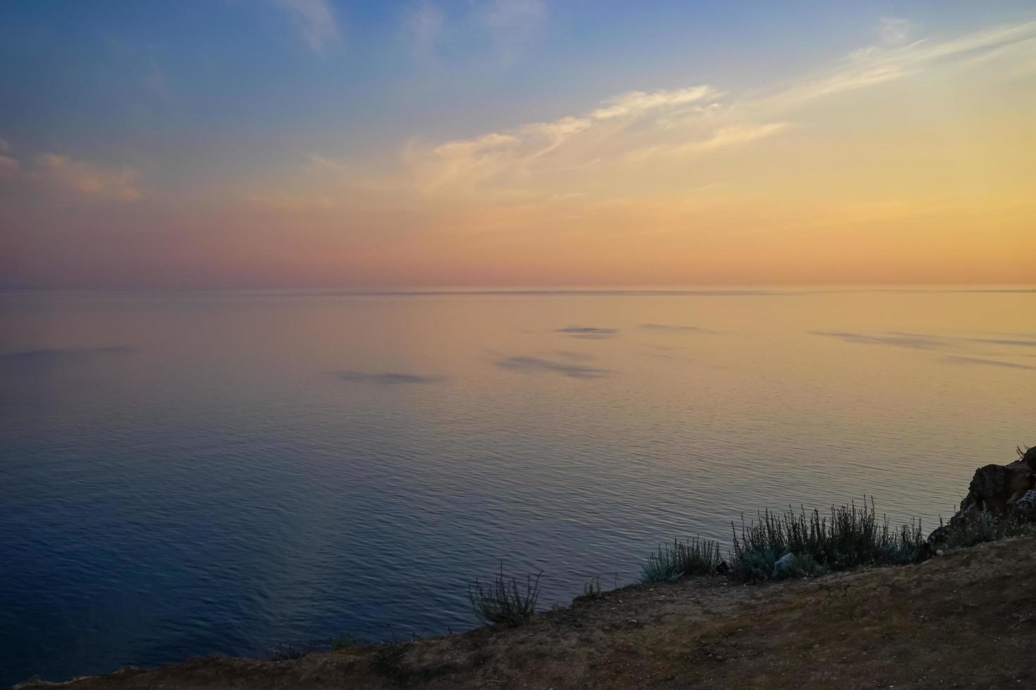 Colorido atardecer nublado sobre un cuerpo de agua foto