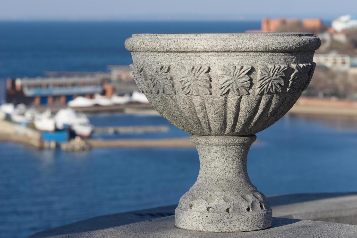 Jarrón de piedra decorativa con un puerto deportivo borrosa en Vladivostok, Rusia foto