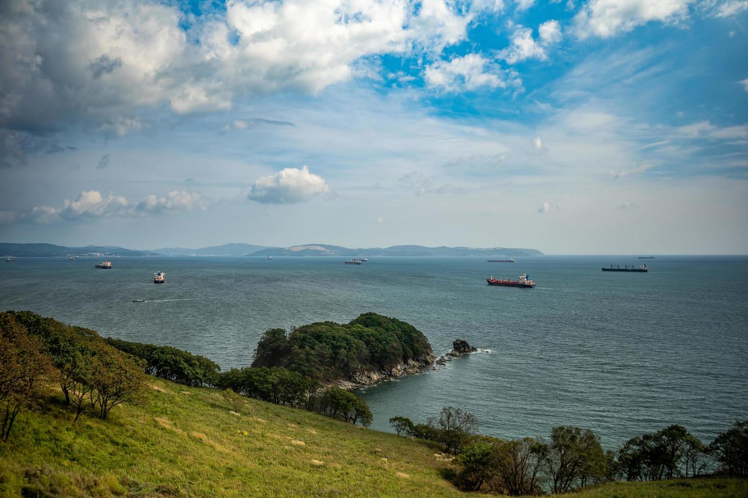 Paisaje marino de una costa con montañas y cielo azul nublado en la bahía de Nakhodka en Nakhodka, Rusia foto