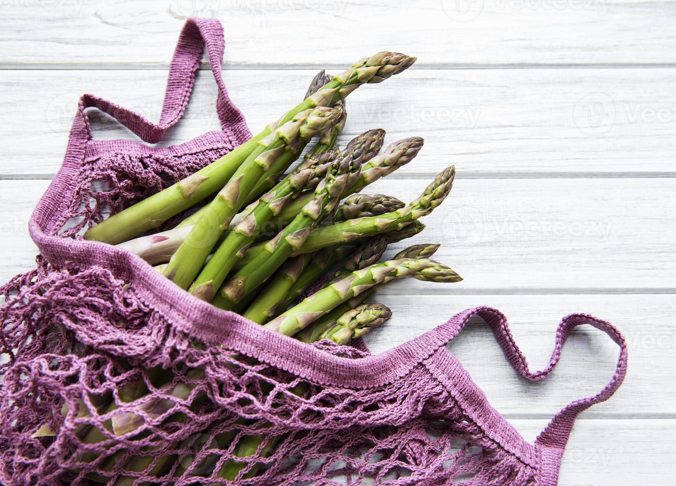 Asparagus stems in a purple bag photo