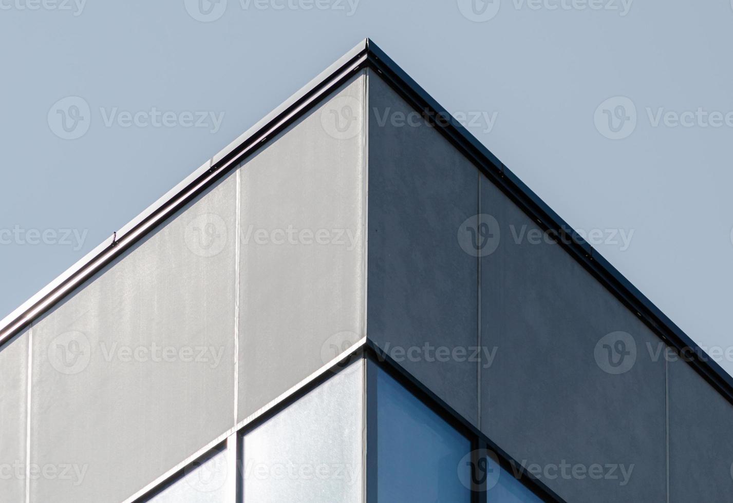 Corner of a gray concrete building with windows photo