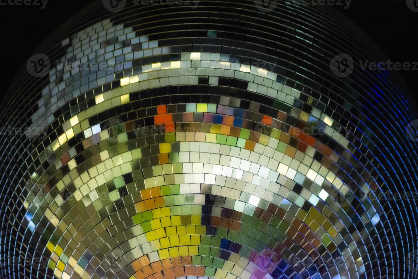 Bola de discoteca de colores sobre fondo negro de cerca foto