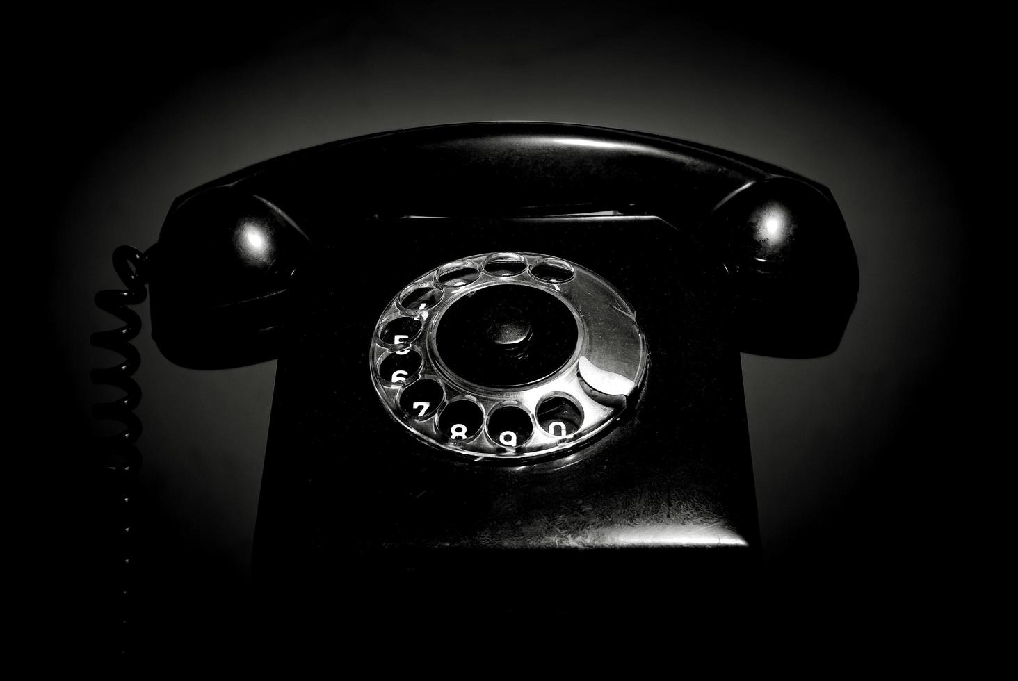 Vintage landline telephone with a handset in black and white. Retro dial phone in a low key. photo