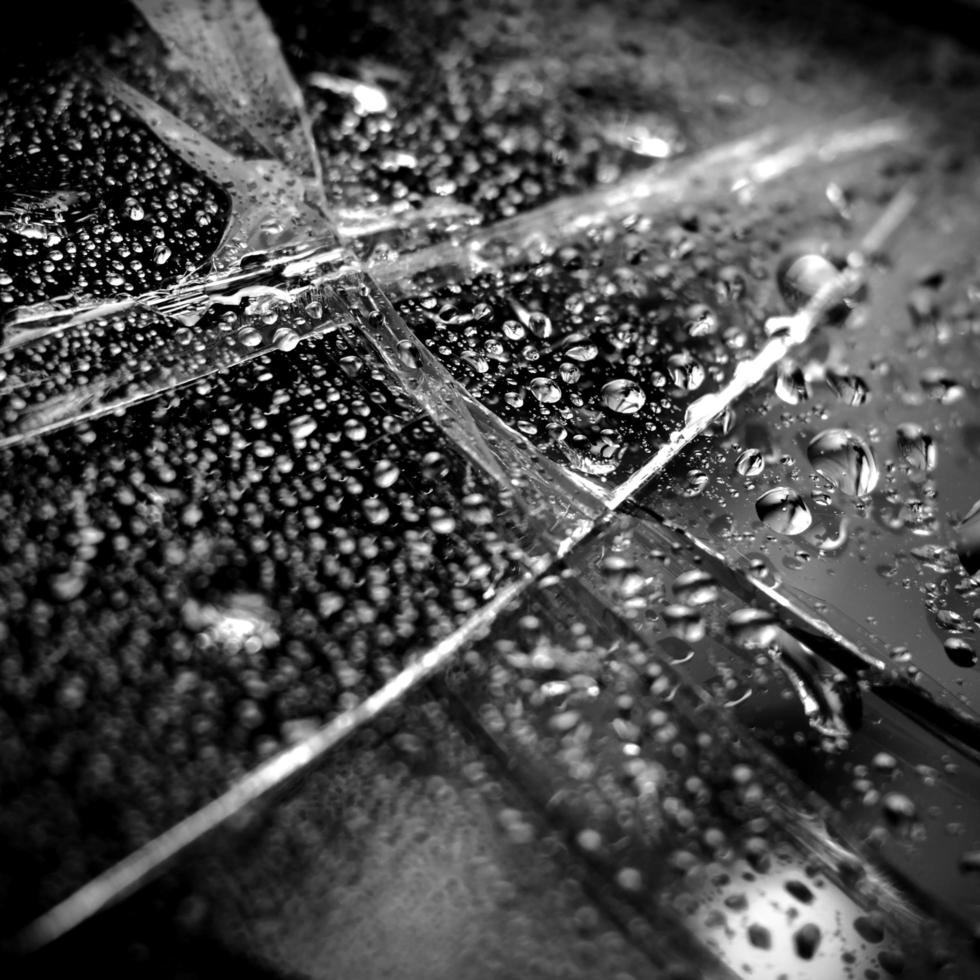 Broken glass background with droplets of water photo