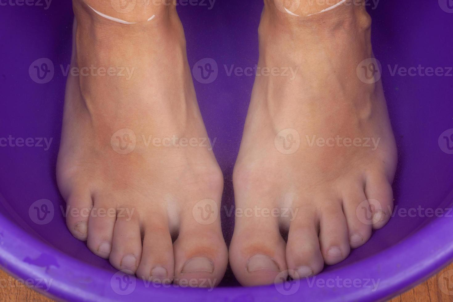 Feet in hot water, foot bath close up. photo