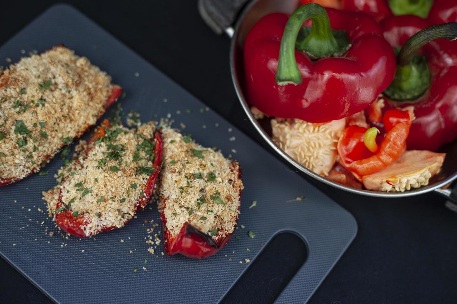 Stuffed red bell peppers on a cutting board photo