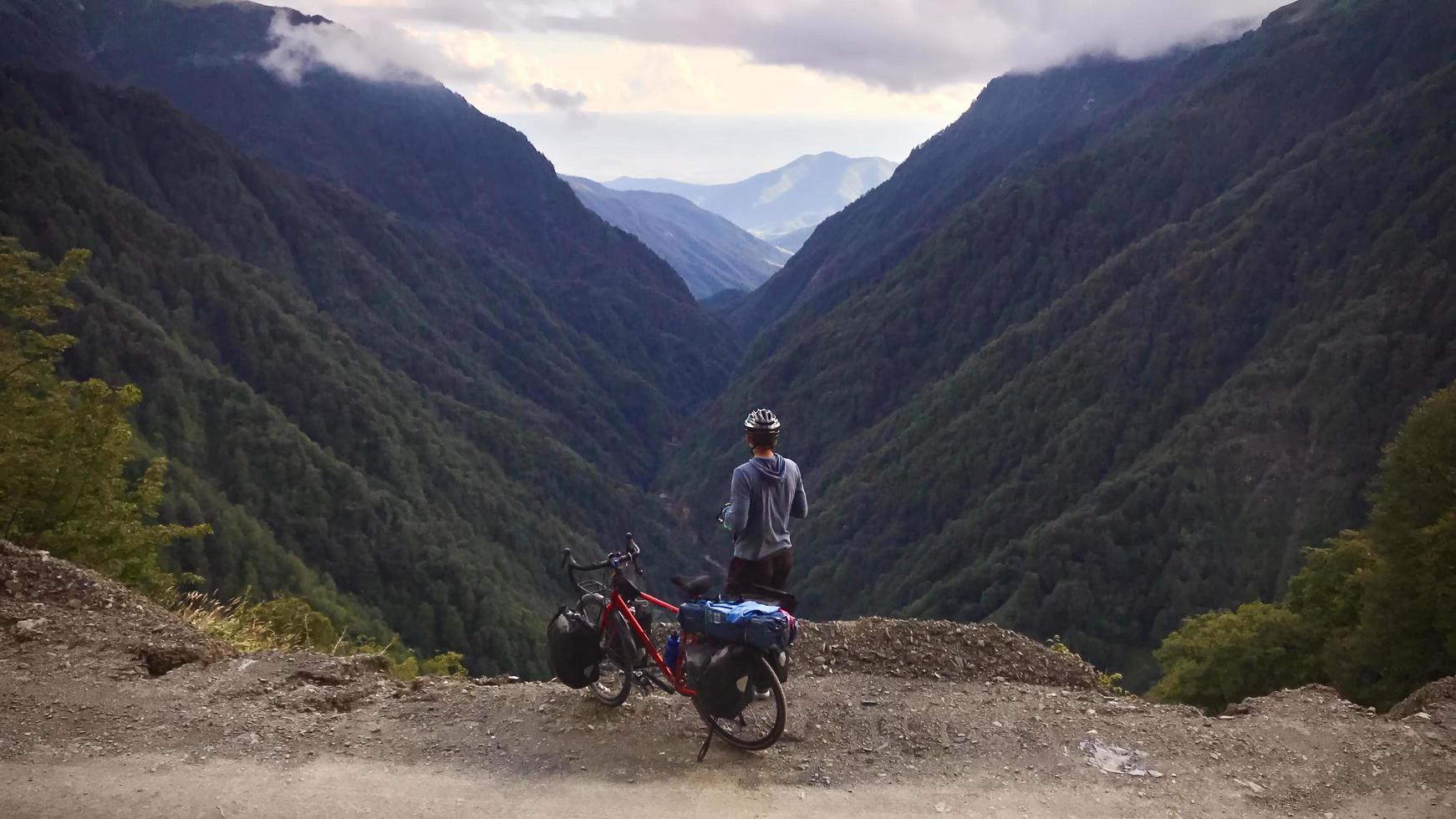 Back view of a cyclist standing with touring bicycle photo