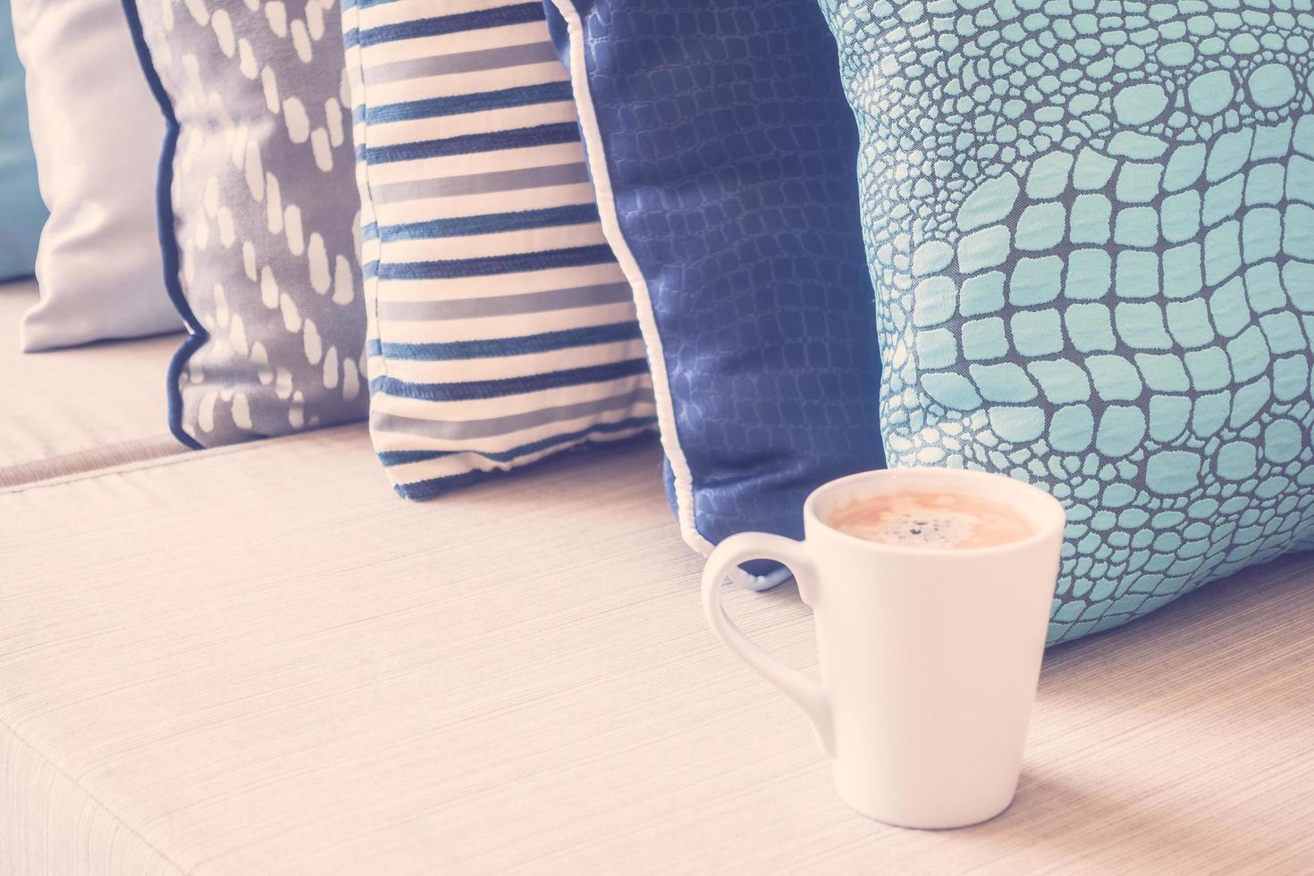 White coffee cup on sofa with pillow decoration photo