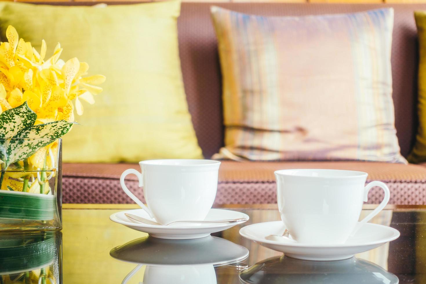 flor y taza de café con leche en la mesa foto