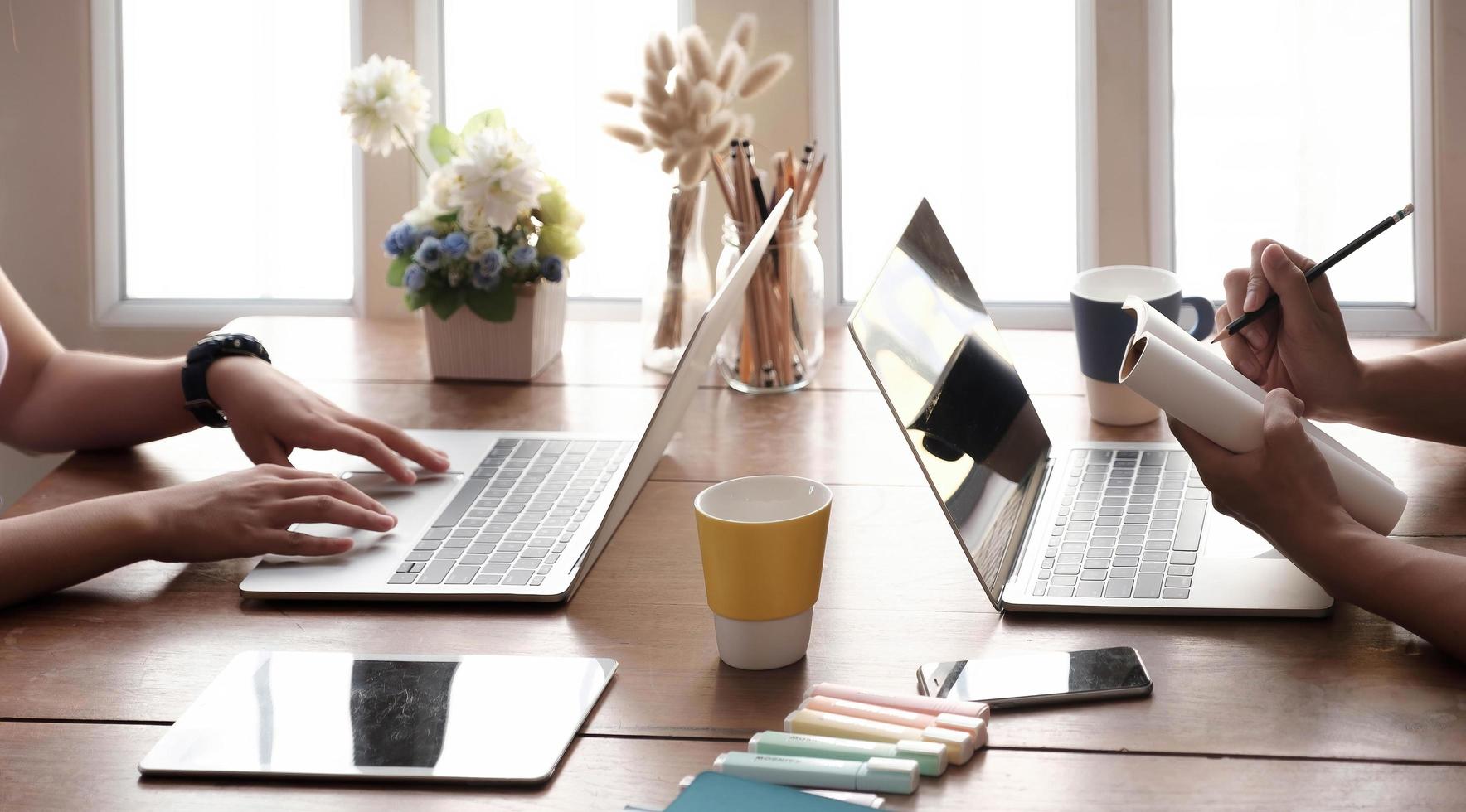 Two people working together at a table photo