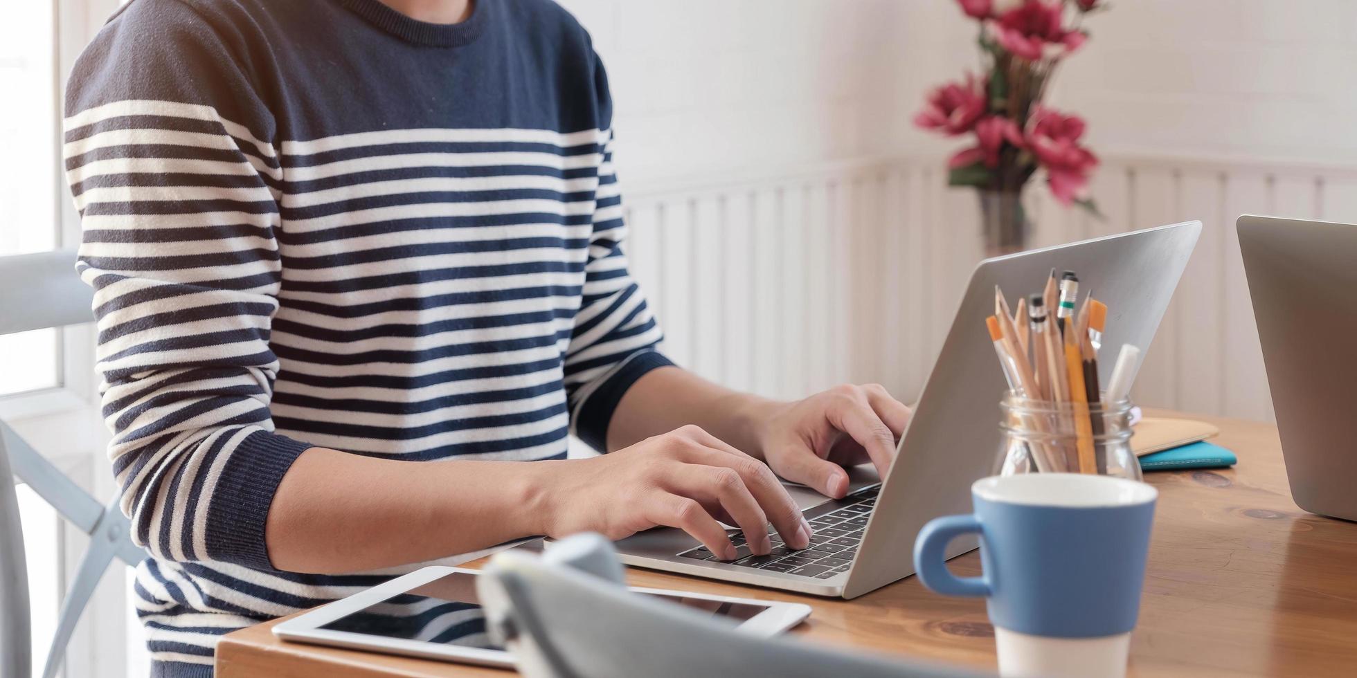 Person in a sweater using a laptop photo