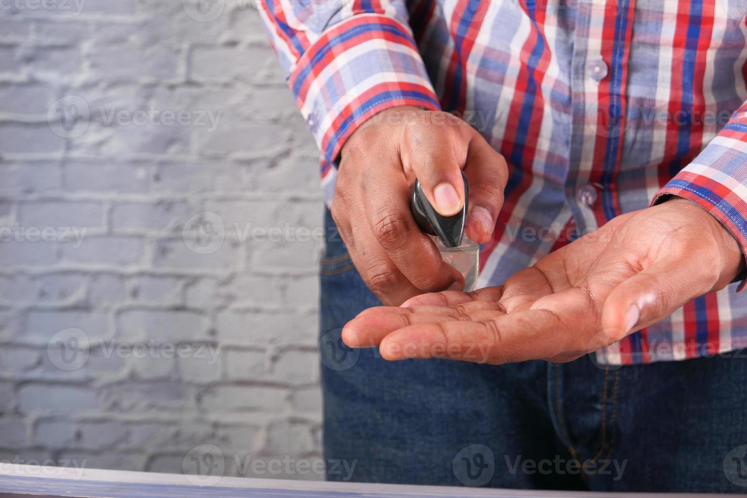 hombre aplicando desinfectante de manos foto