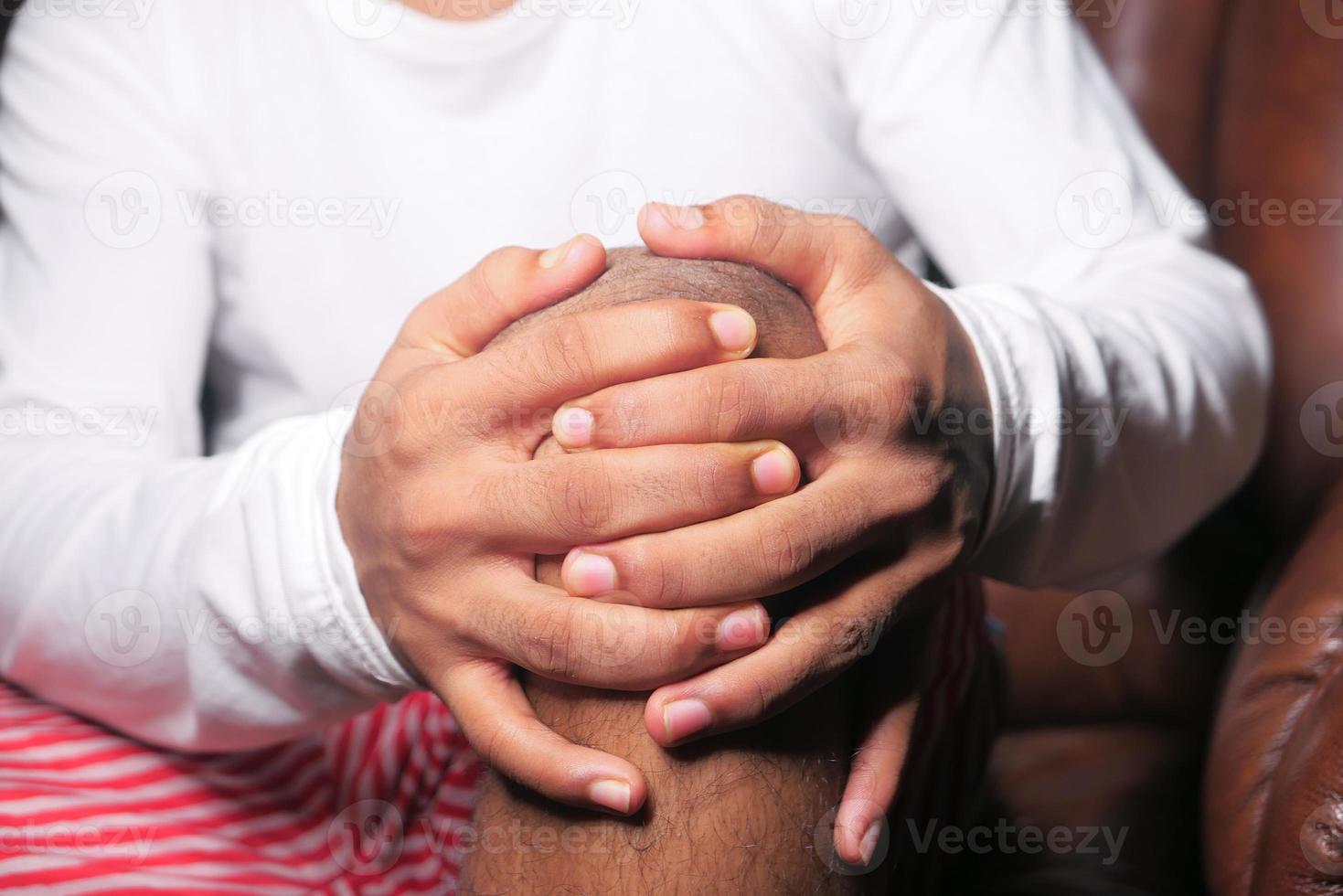 Boy holding knee in pain photo