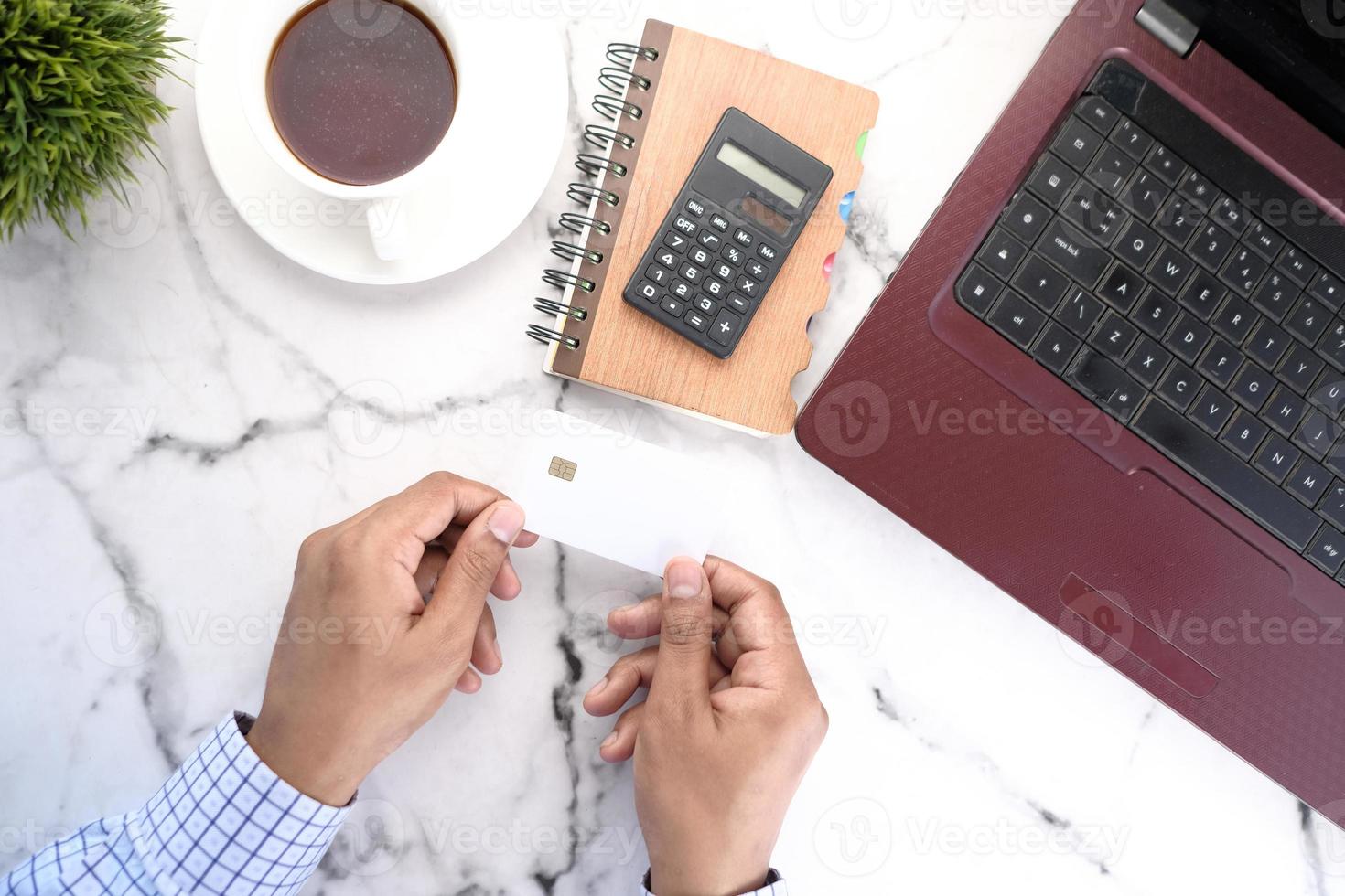 Man holding a credit card at desk photo