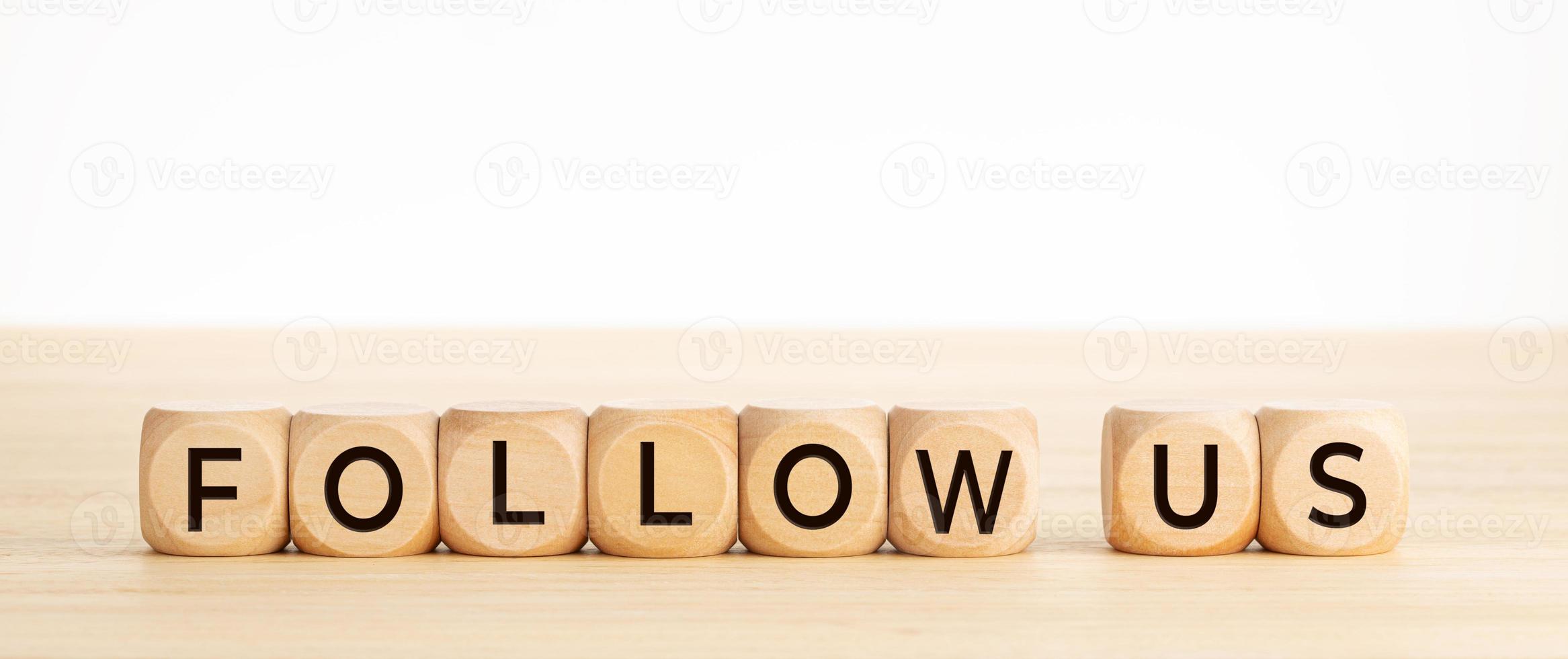Follow us word on wooden blocks on wood table photo