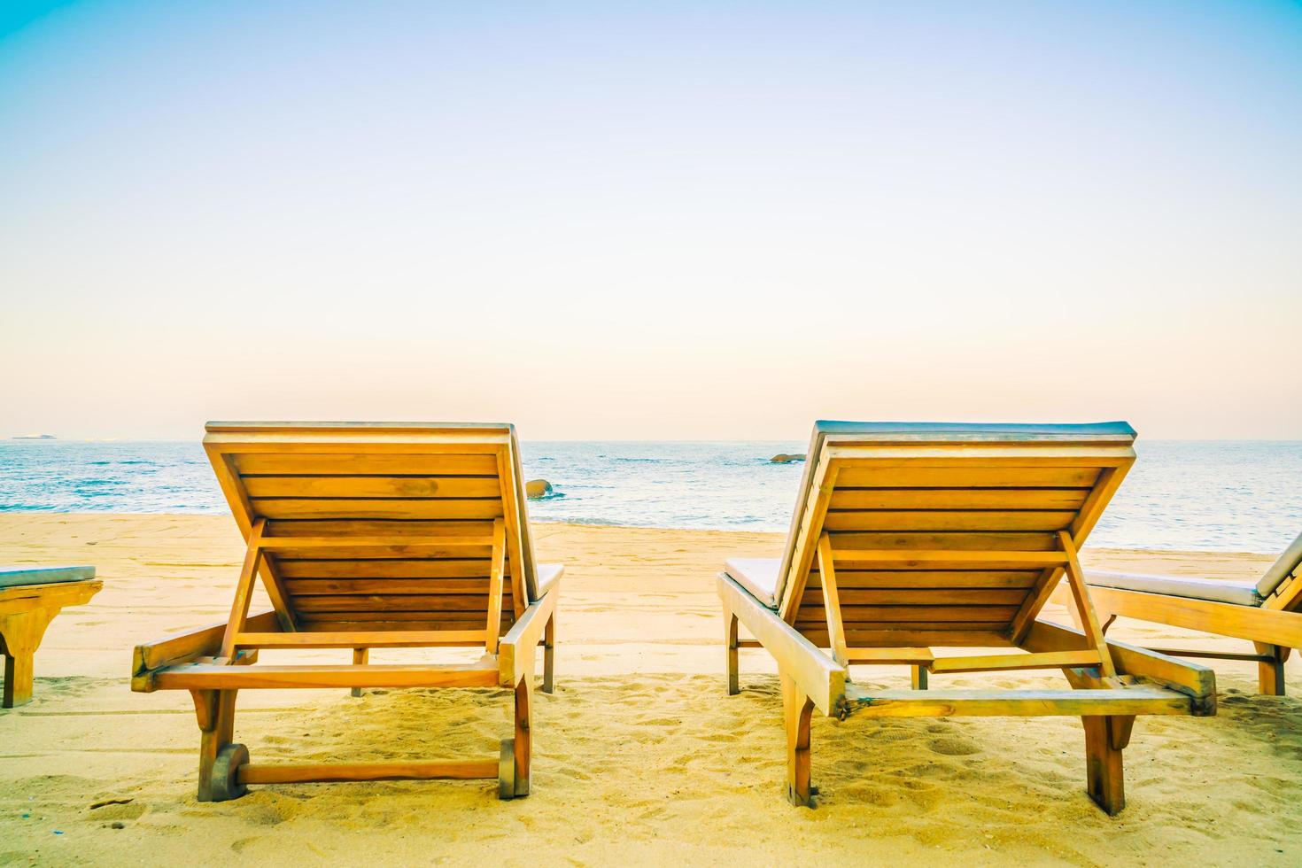 tumbonas vacías para tomar el sol en la playa foto