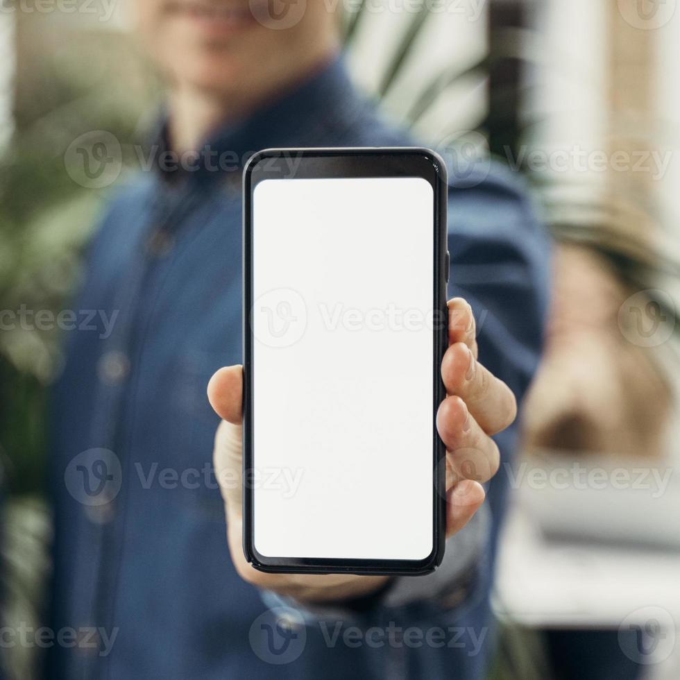 empresario mostrando teléfono de pantalla vacía foto