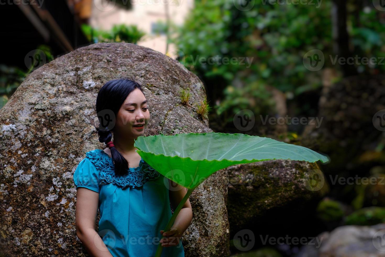 mujer sosteniendo una hoja gigante foto