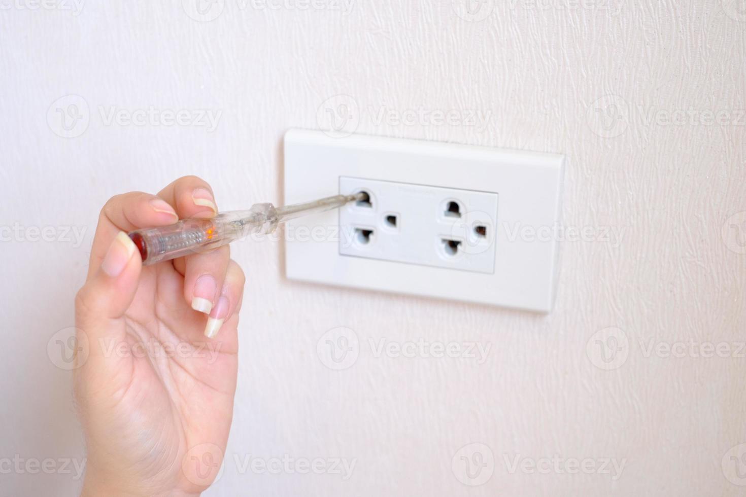 Person putting a screwdriver into an electrical outlet 2300391 Stock