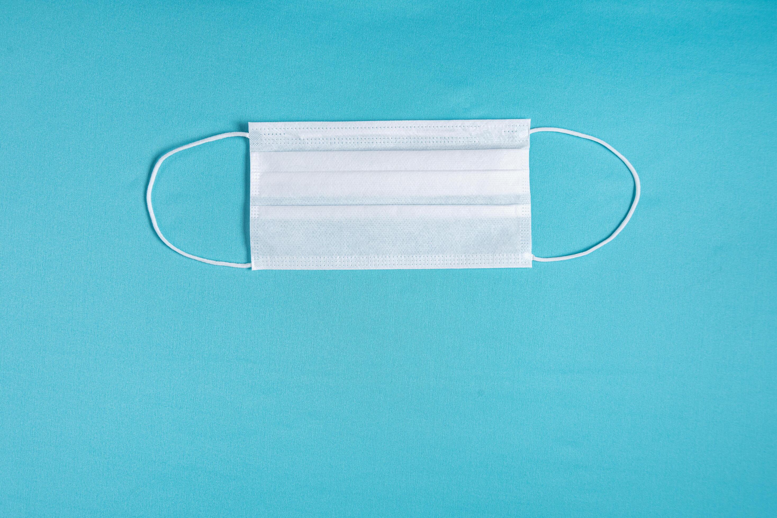 Surgical mask over minimalist blue background 2300620 Stock Photo at