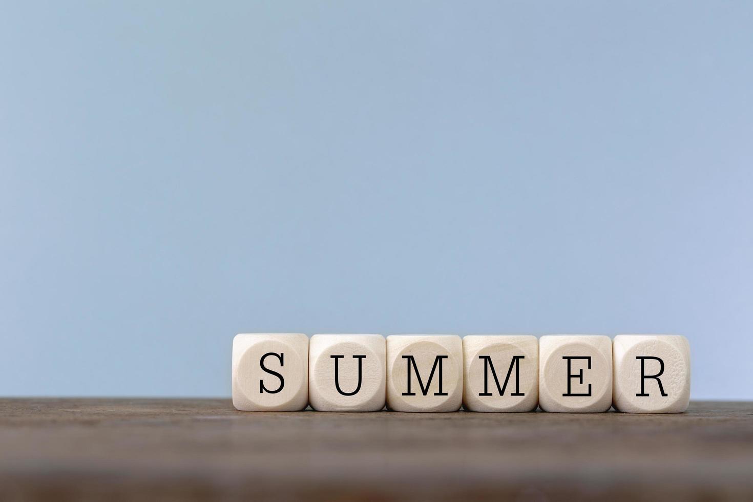 Summer word written in wooden cube on wooden table photo