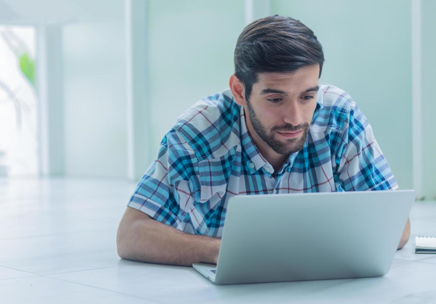 joven empresario que trabaja con una computadora portátil en casa foto