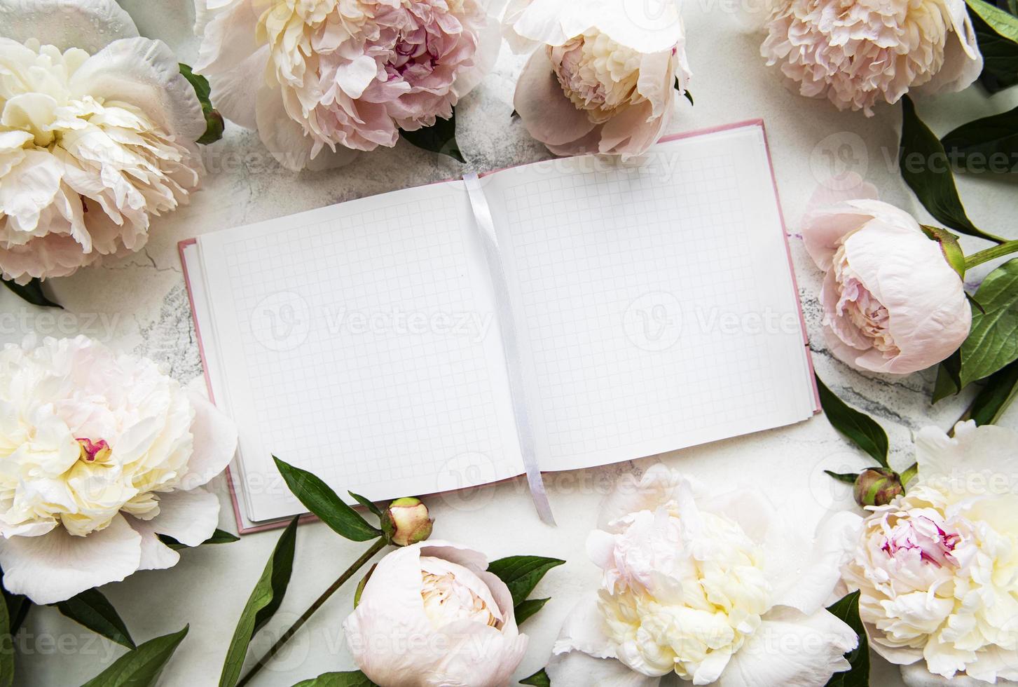 flores de peonía y cuaderno vacío foto