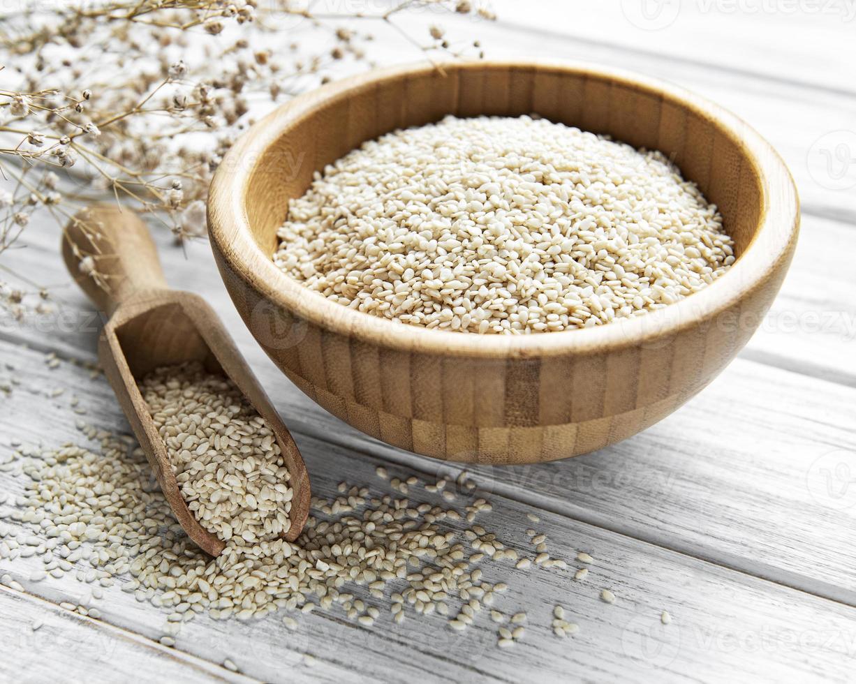 Sesame seeds in a bowl  on a rustic table photo