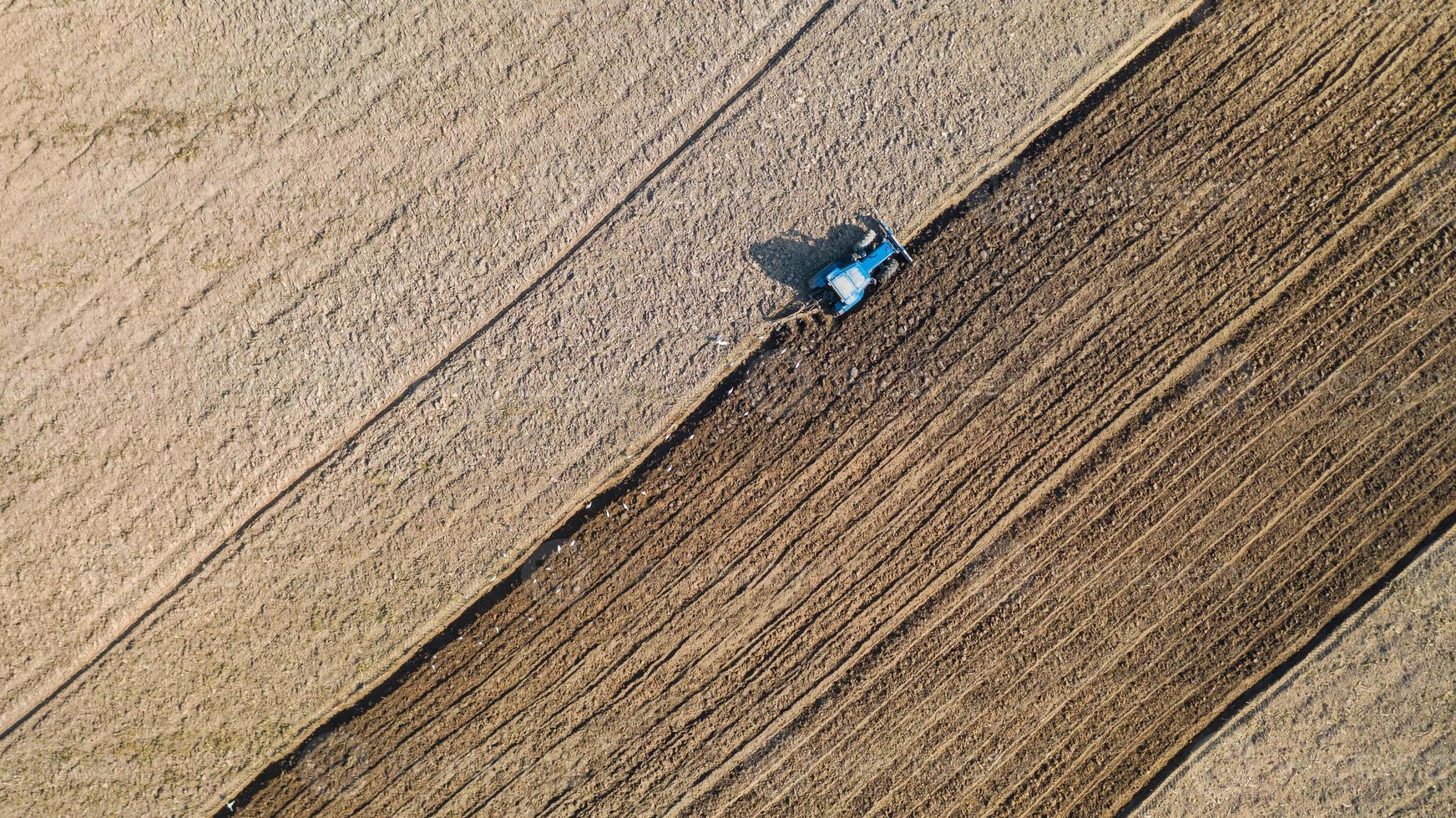 Top view of agricultural tractor vehicles working at field photo