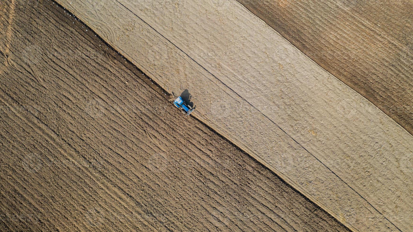 Top view of agricultural tractor vehicles working at field photo