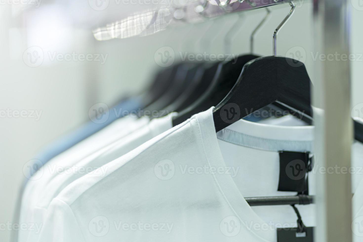 Close up of White t-shirts on hangers, apparel background photo