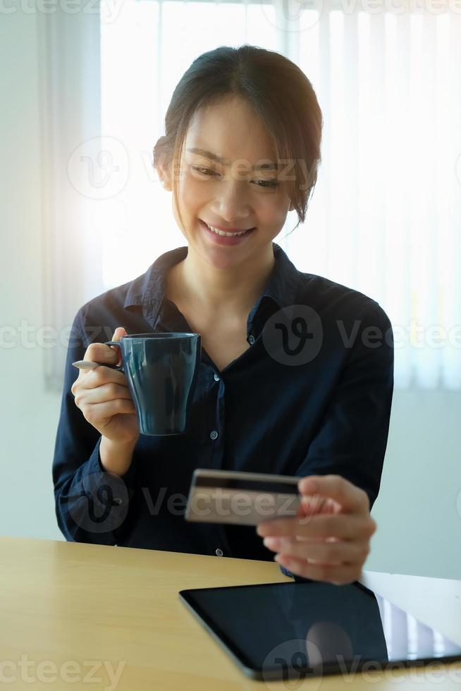 mujer sosteniendo café y tarjeta de crédito foto