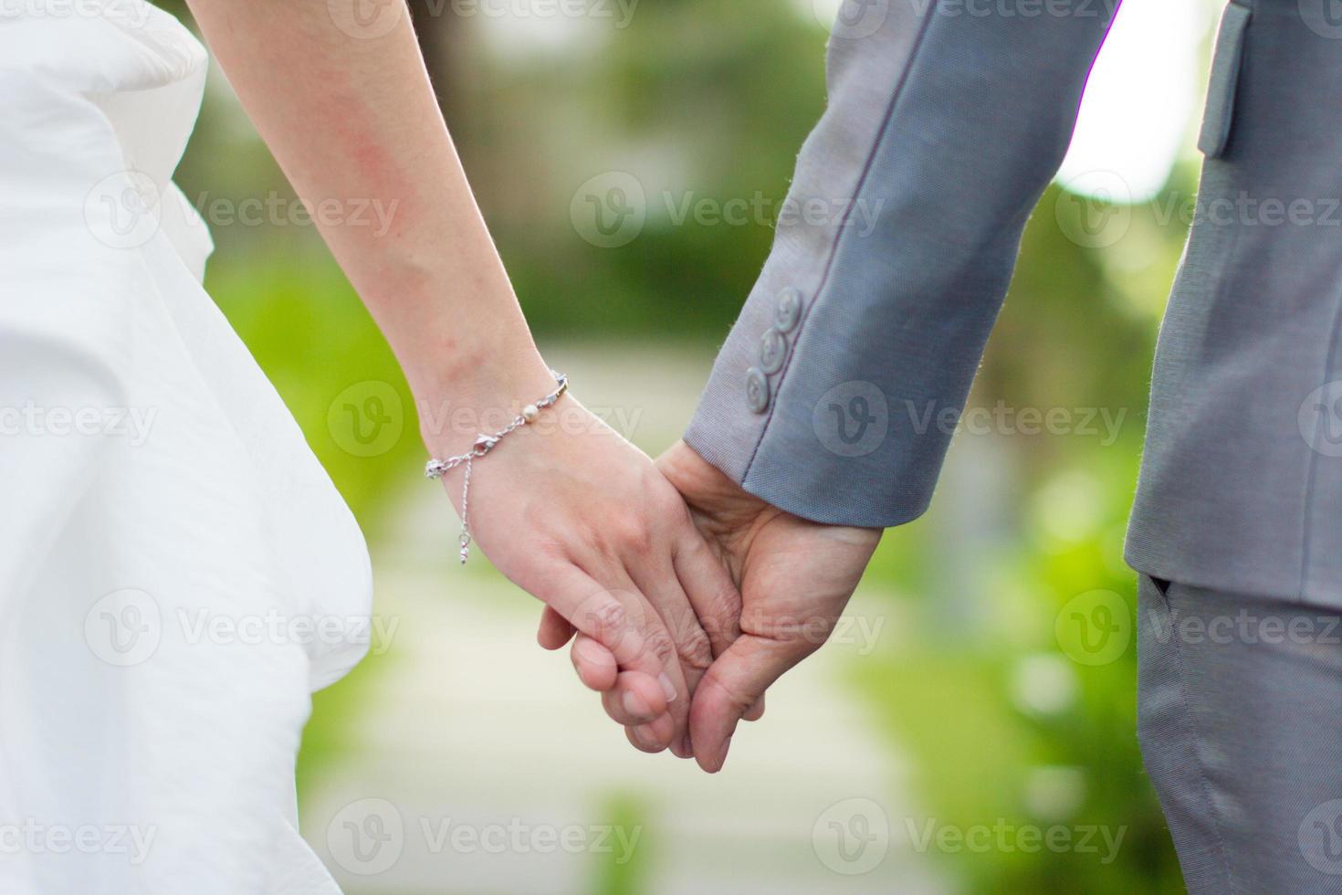 La novia y el novio matrimonio tomados de la mano en la ceremonia de la boda foto