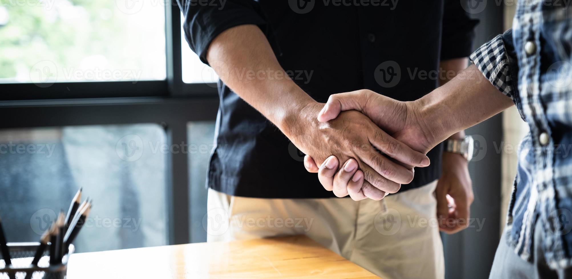 Image of successful businessmen, partnership handshaking after acquisition. Meeting for signing contracts and group support concept. photo