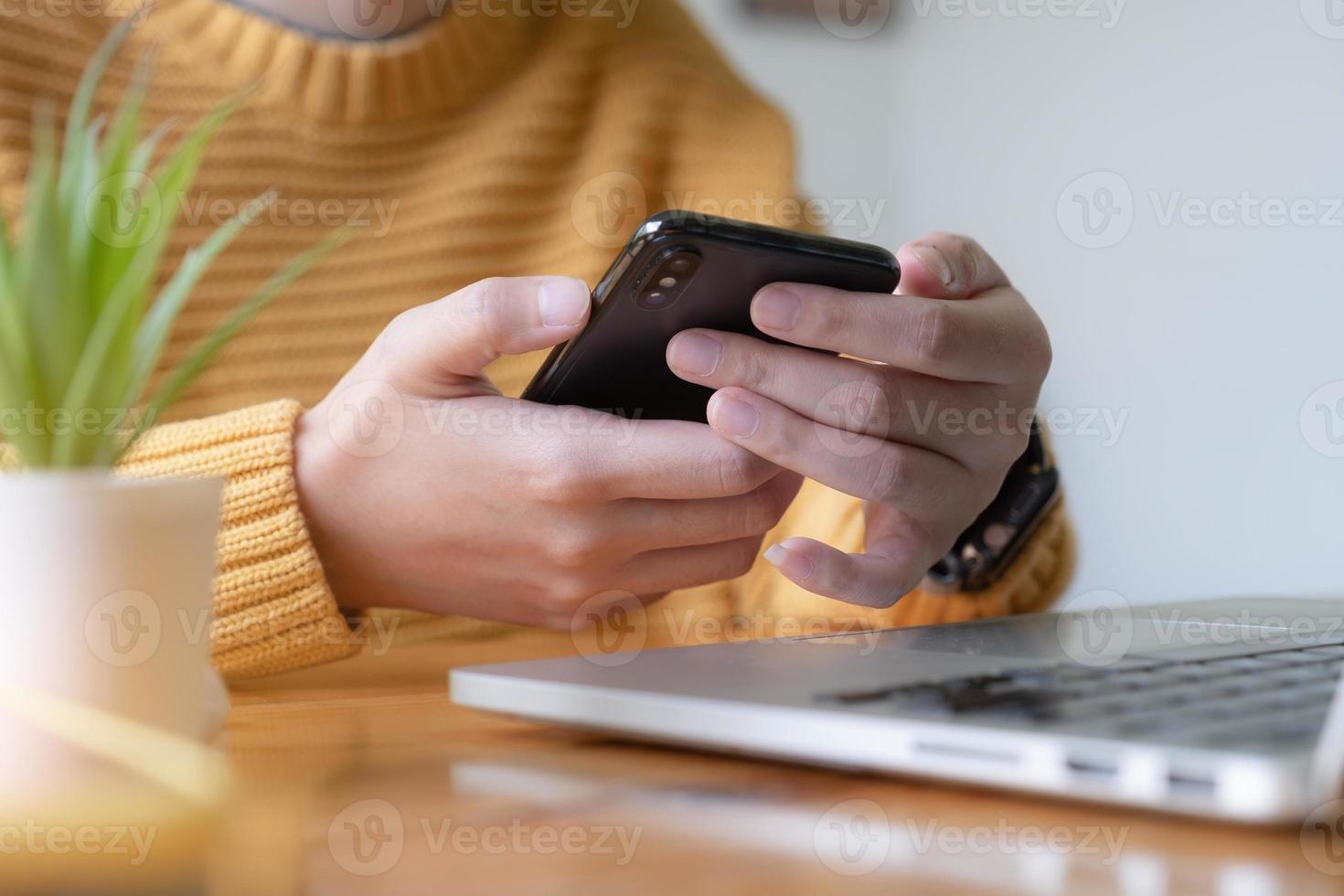 Young Asian woman disconnecting from social media and turning off her smartphone. Digital detox concept. photo