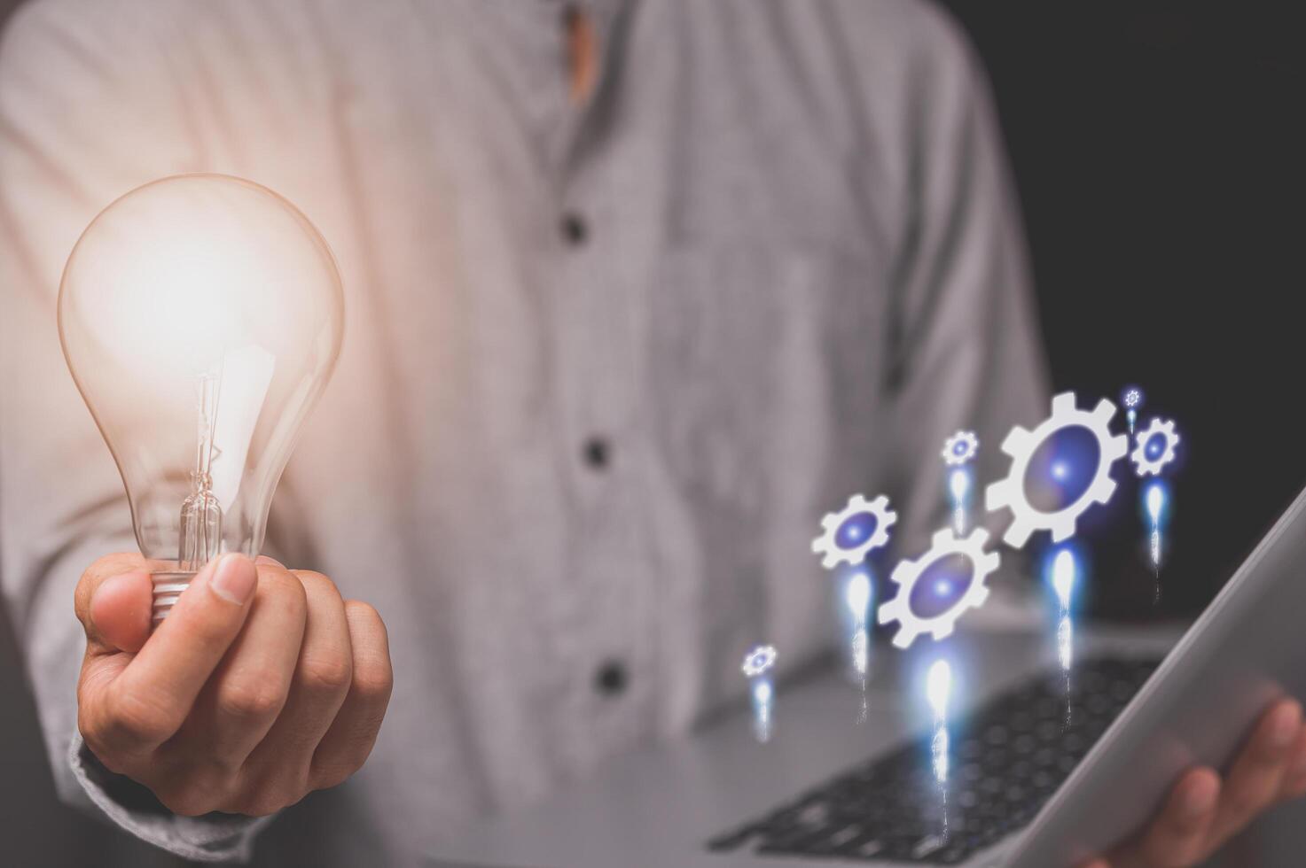 Hand showing a light bulb and gear symbol photo