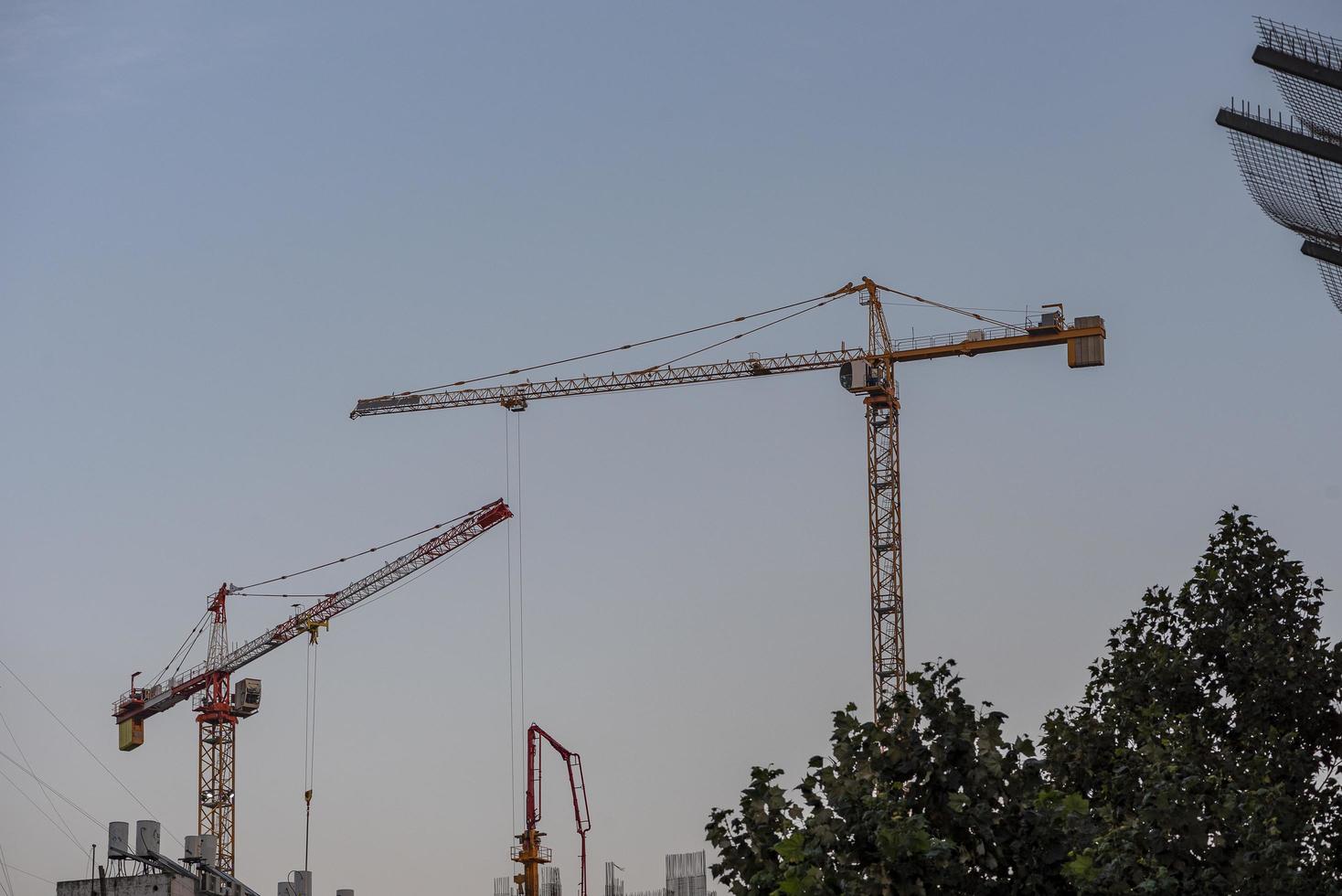 Industrial landscape with silhouettes of cranes on the sunset background photo