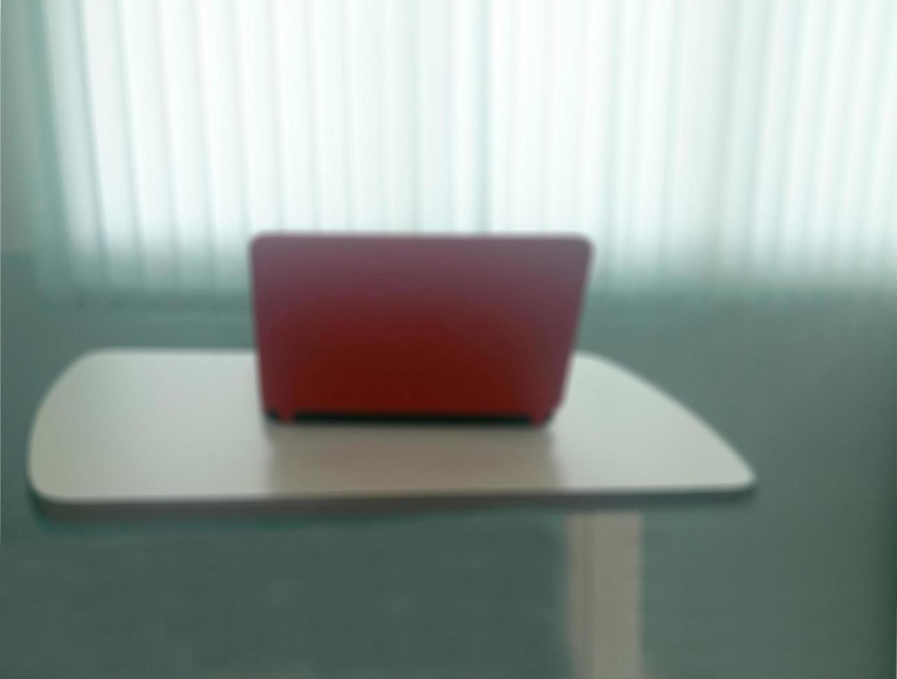 Blurred background notebook on table with blind light curtain photo