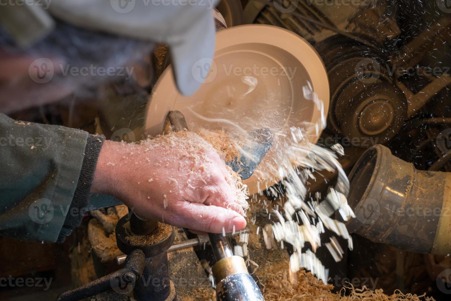 Hacer un cuenco de madera en un torno en un pequeño taller antiguo foto