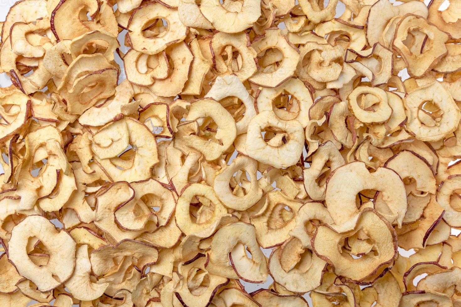 Many dried apple pieces evenly distributed as a background photo