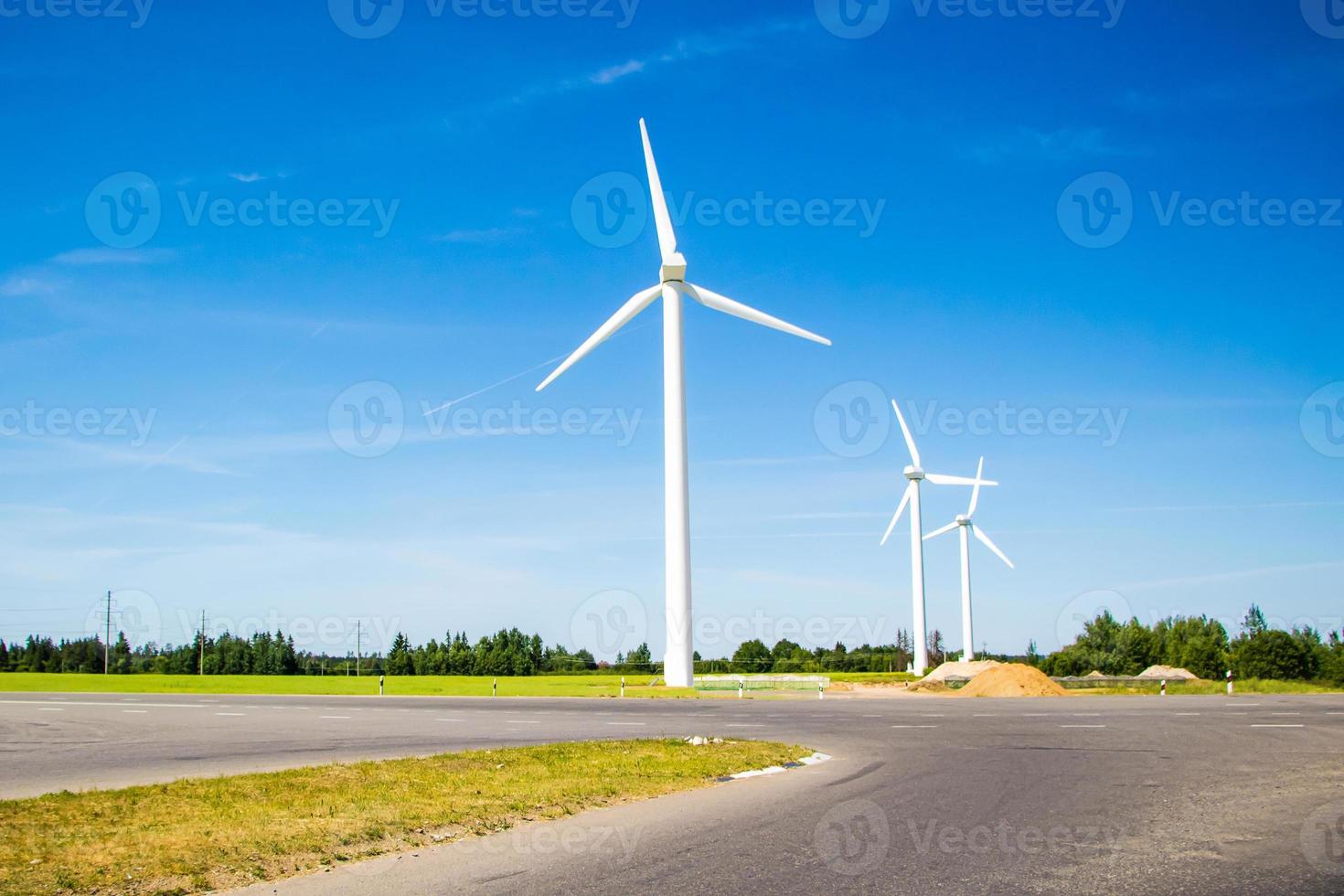 molinos de viento a lo largo de la carretera contra el cielo azul foto