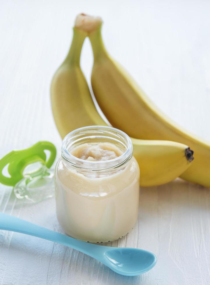 Jar of banana puree,  and bananas photo