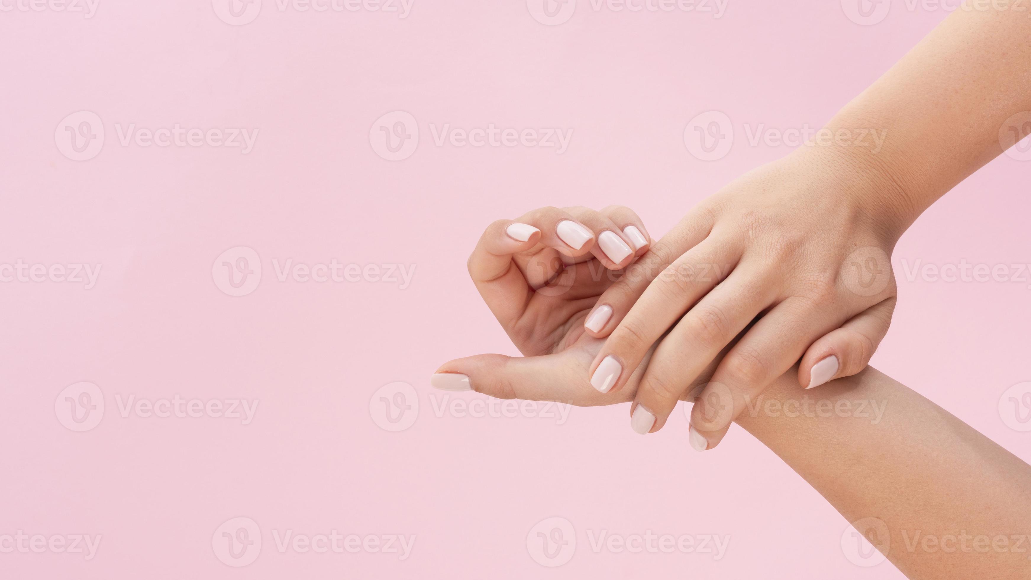 Mujer mostrando su manicura sobre fondo rosa con espacio de copia foto