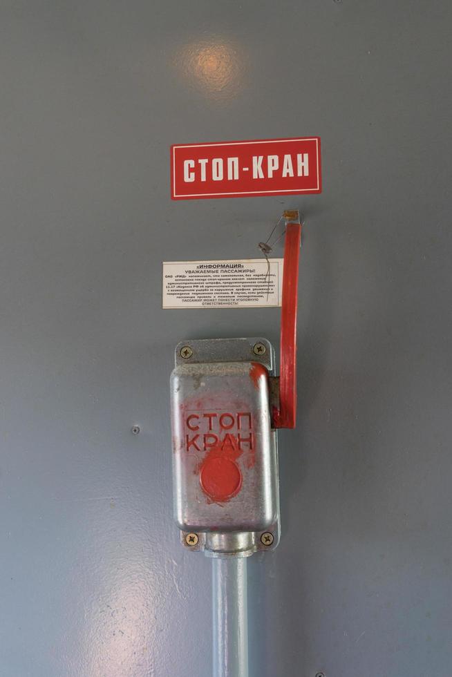 Closeup of emergency brake lever on brown wall in train photo