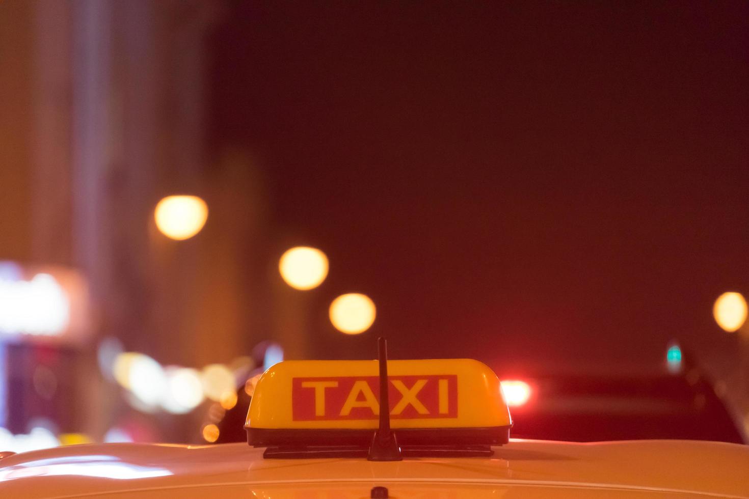 Signo de taxi en el techo del coche sobre un fondo borroso foto