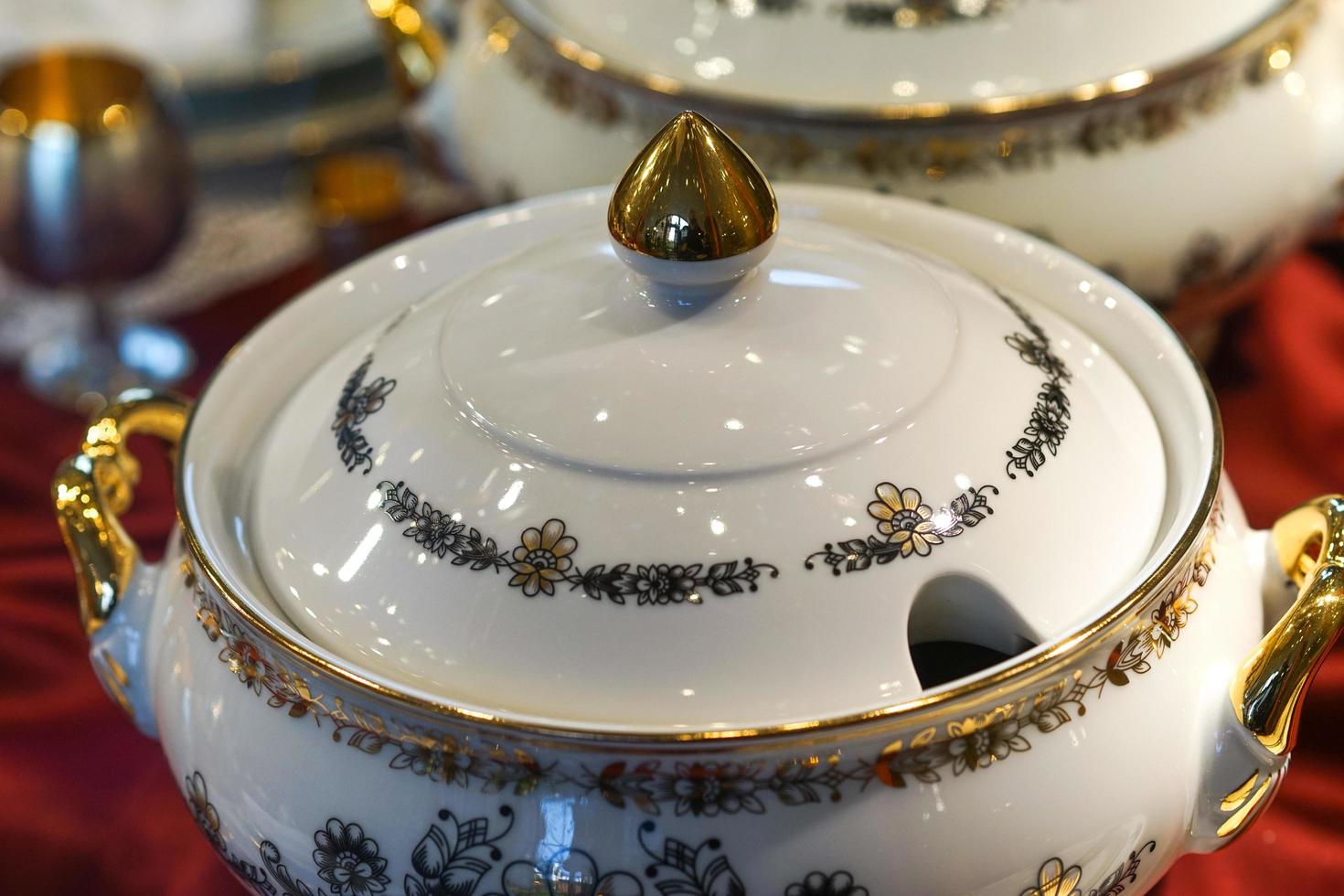 Background with white porcelain tableware with floral ornament and gilded details. photo