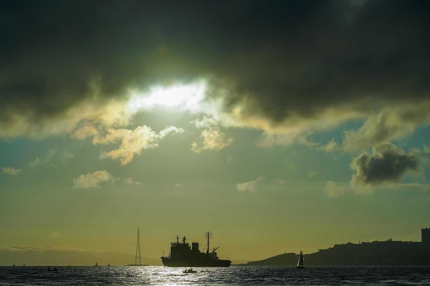 paisaje marino con una vista de la silueta de la ciudad y el barco foto