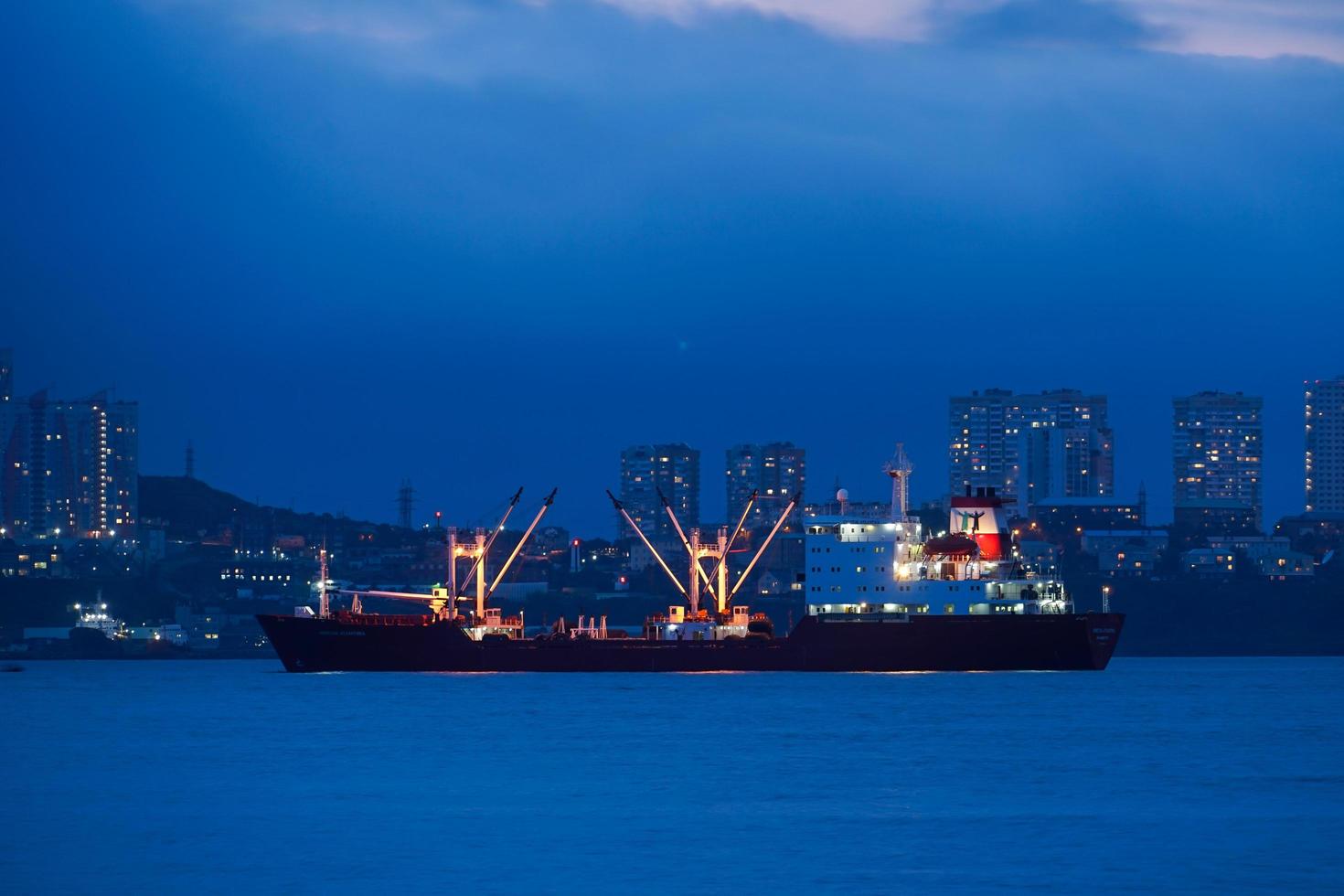 paisaje nocturno con el mar y los barcos en el fondo de la ciudad. foto