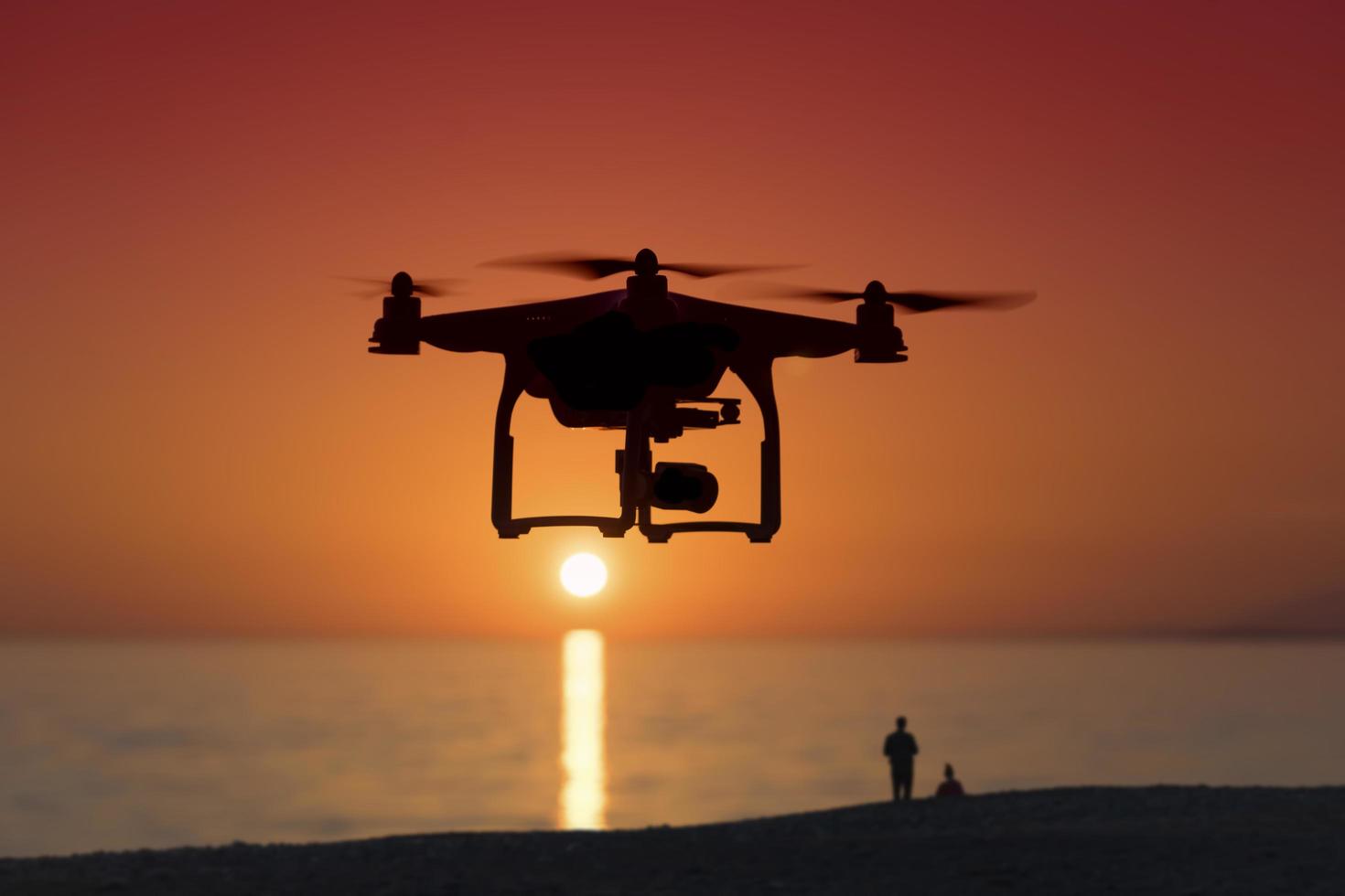 Silhouette of a quadrocopter on sunset background photo