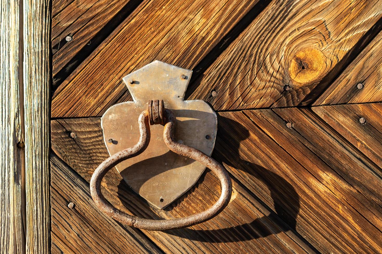 Metal door handle on the background of a wooden door photo
